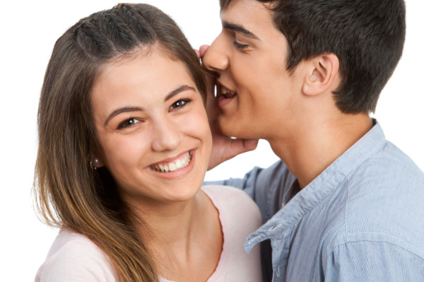 Boyfriend whispering secrets to girlfriend.